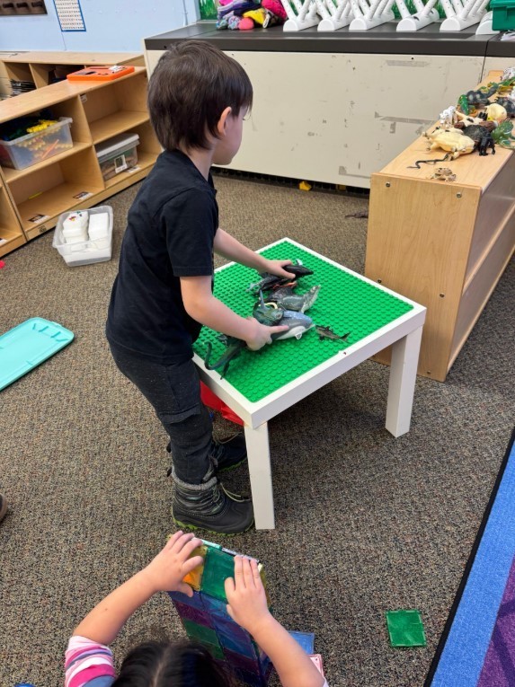 A little boy playing with legos.