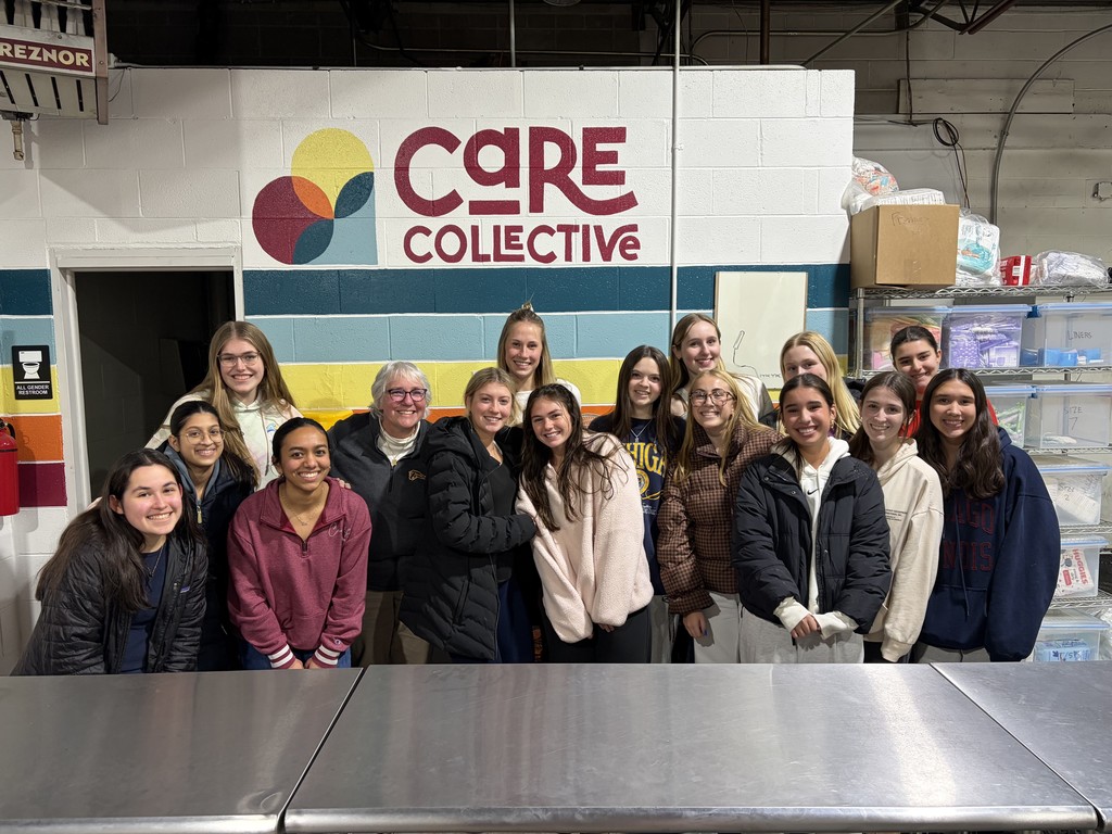 a group of girls pose for a photo in front of a sign that says care collective