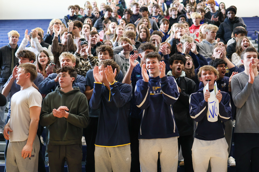a student section cheering in a gym