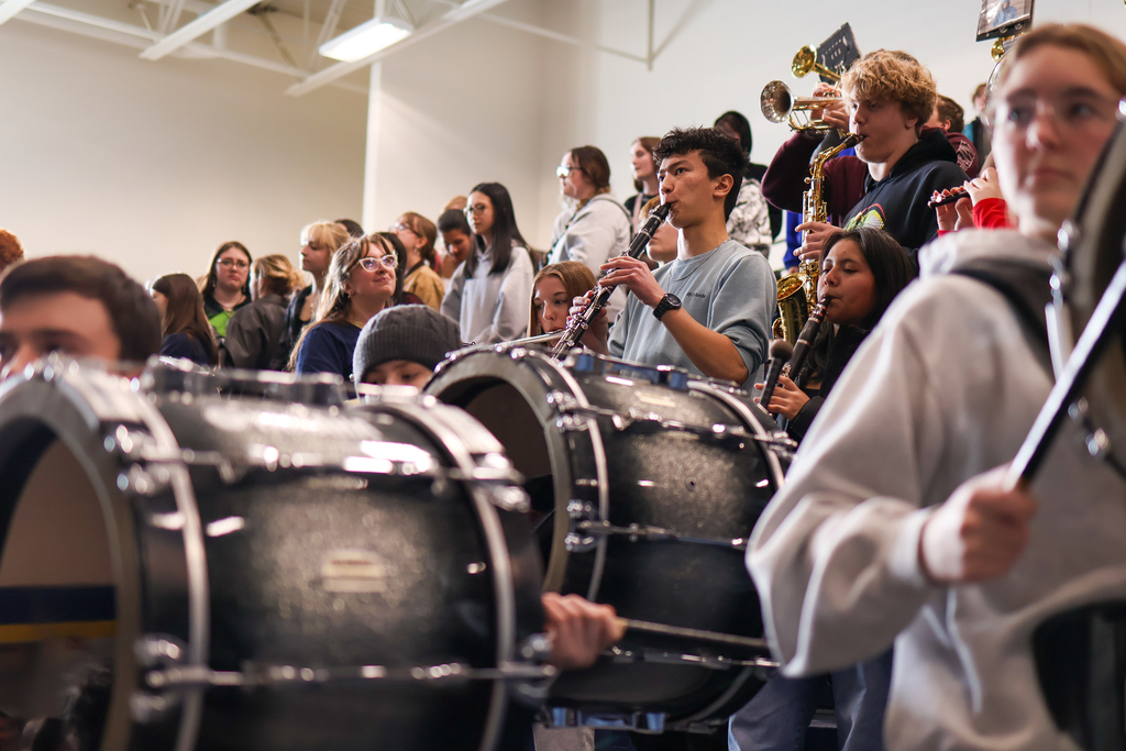 marching band members perform in gym