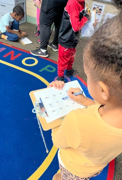 A female student using a clipboard to draw on.