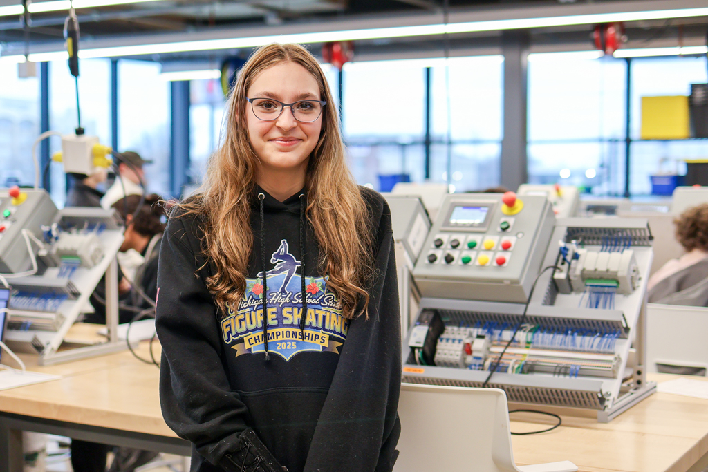 a girl poses for a photo in a mechatronics lab