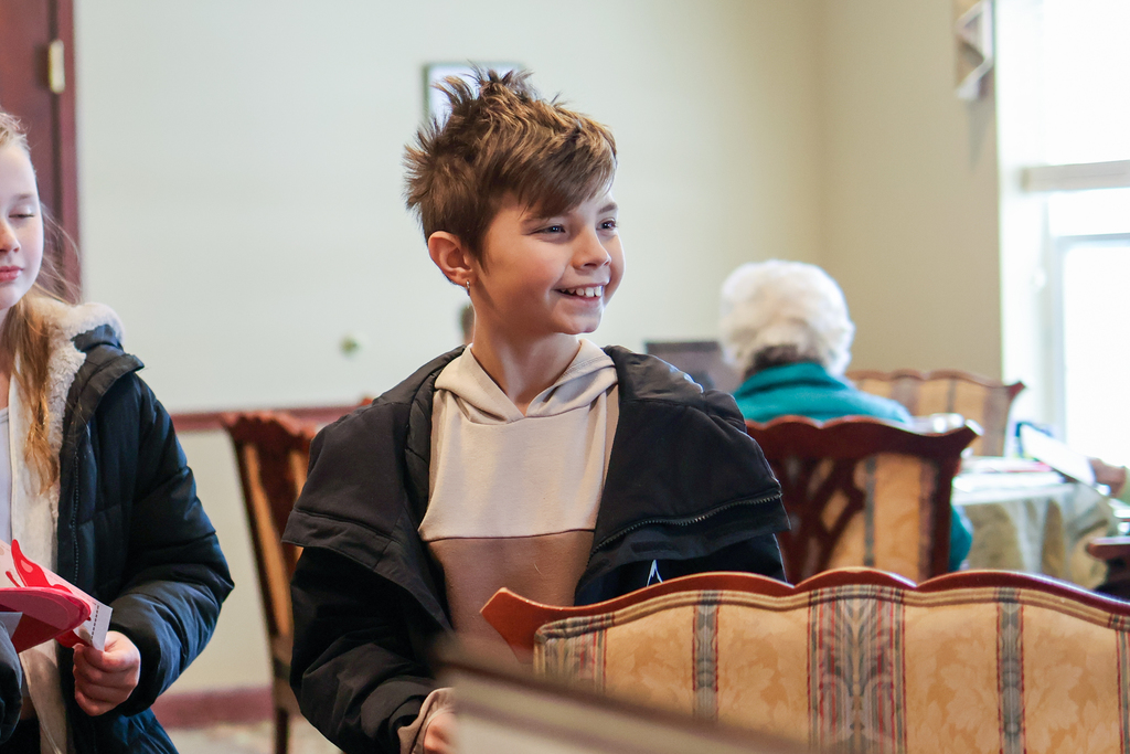 a boy smiles standing in a cafeteria
