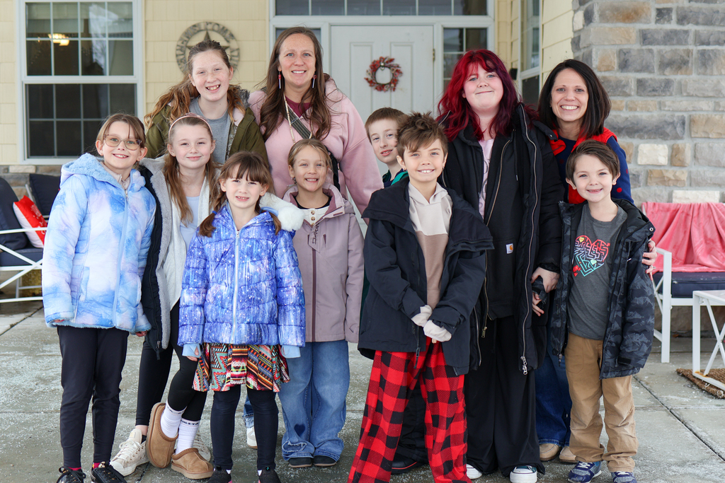 a group of students and their teachers pose for a photo outside