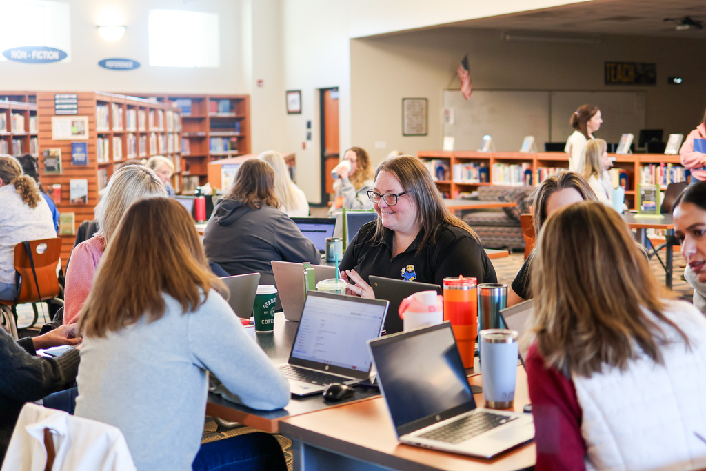 a group of women sitting around a table in a  library