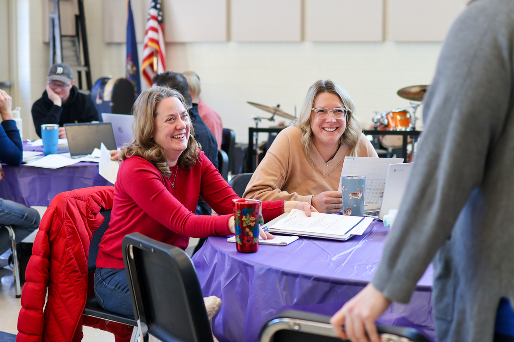 two women smiling sitting at a table