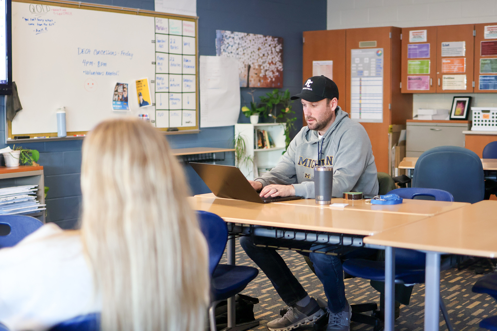 a man working on a laptop  in a classroom