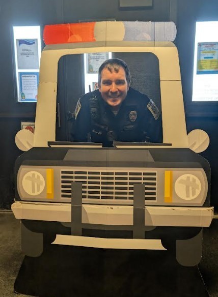 Officer Burleson posing in a pretend police car.