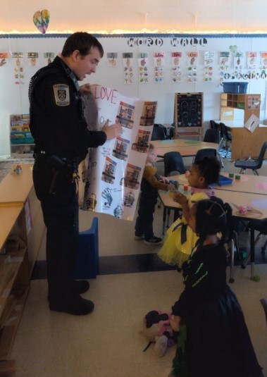 Officer Burelson looking at a poster with two children.