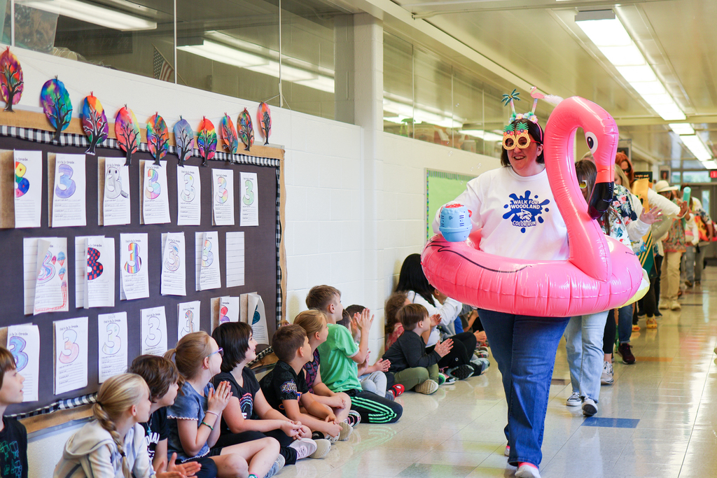 a woman wearing pool floaties walks down a school hallway