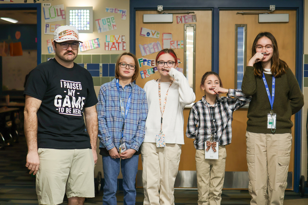 a group of kids dressed like their teacher including khakis, badges and fake mustaches 