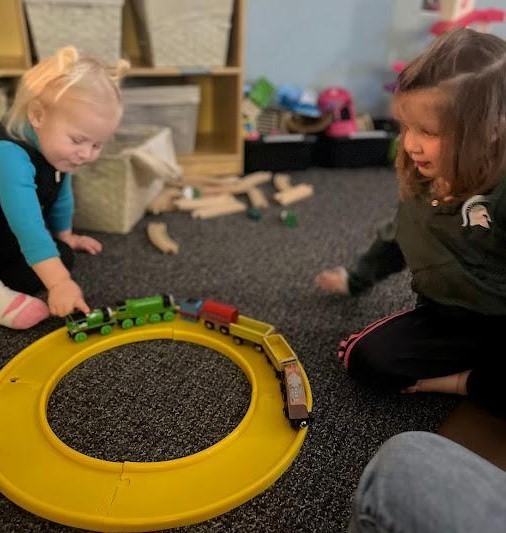 A boy and girl sharing a train track.