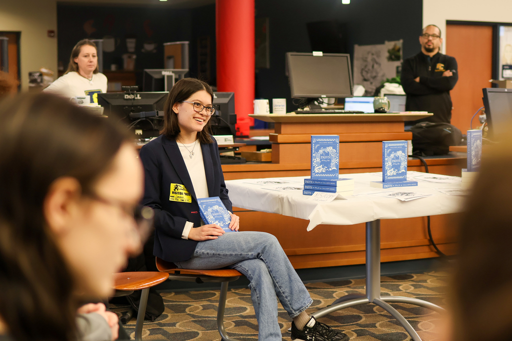 a woman sitting in a library holding a book