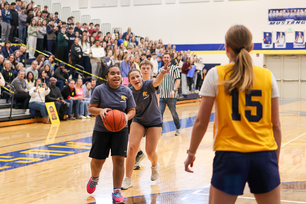 a girl prepares to shoot a basketball in a school gym