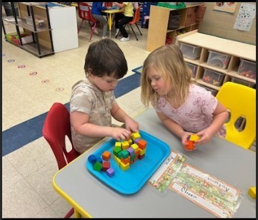 A female and male students working on block patterns together.