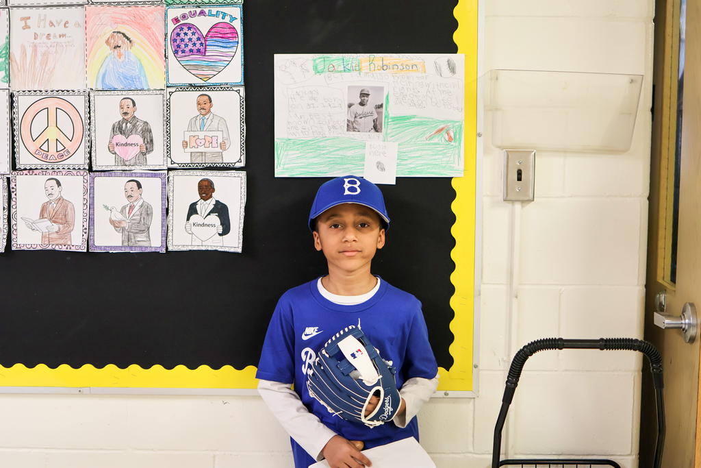 a boy dressed as a baseball player poses for a photo