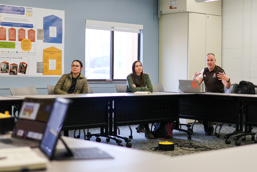 a man speaking at a table in a conference room