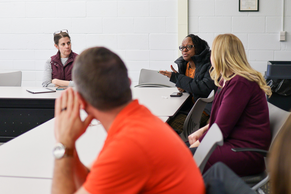 a woman speaking at a conference room table