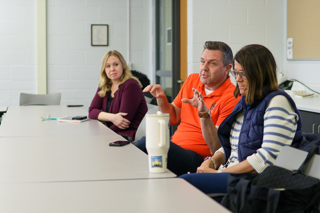 a man speaking at a table in a conference room