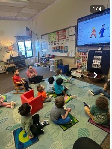 Students sitting together at the rug in a classroom.