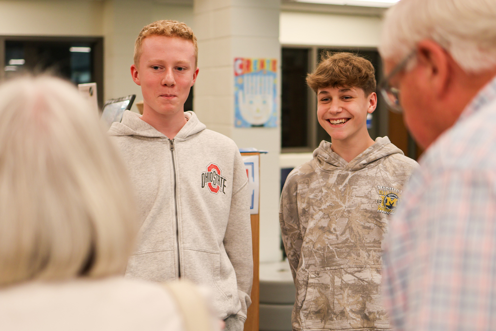 two boys smiling at two adults in a library
