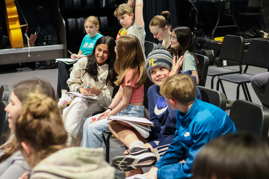 students sitting together in chairs inside a classroom