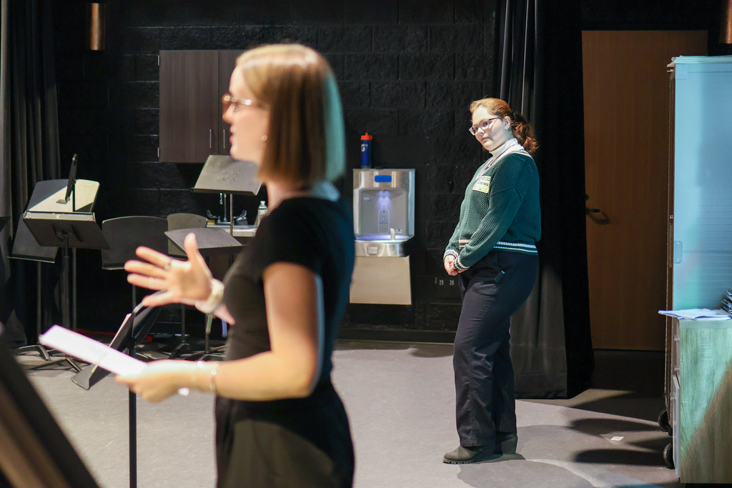 two women speaking at the front of a classroom