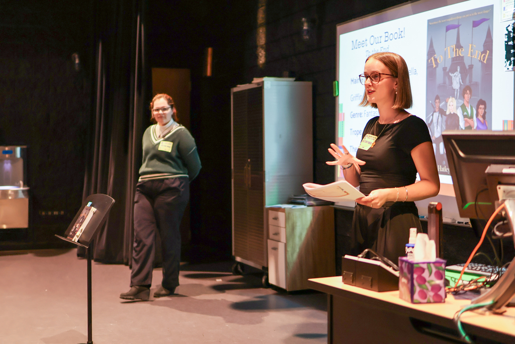 two women speaking at the front of a classroom