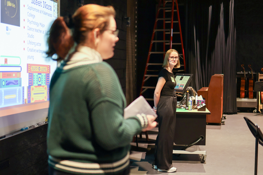 two women speaking at the front of a classroom