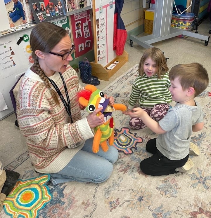 Teacher playing with puppets.