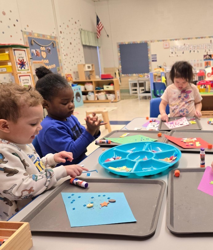 Three students at a table together sorting objects.