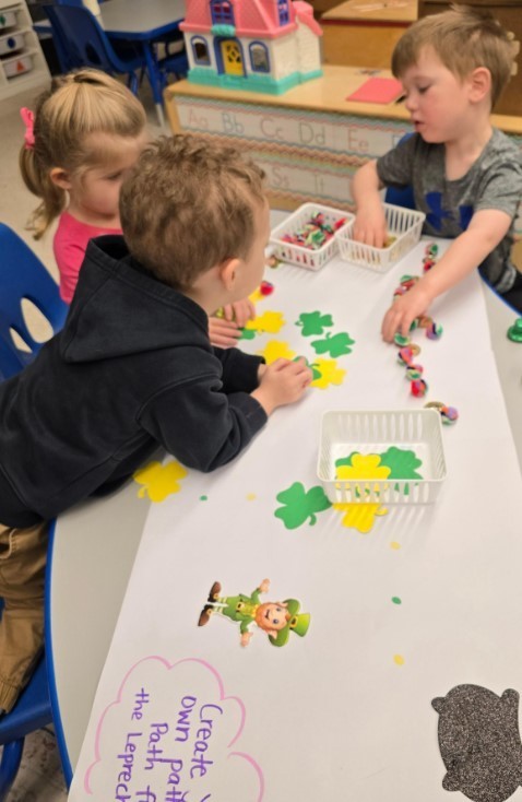 Three students creating a shamrock trail together. 