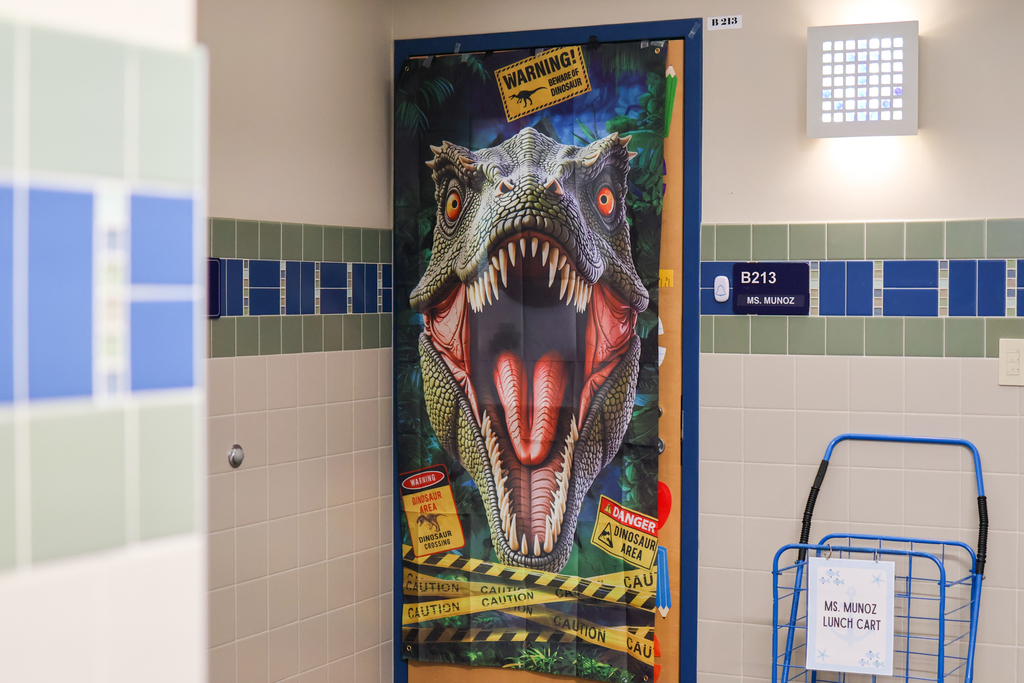 a photo of a dinosaur hanging on a classroom door