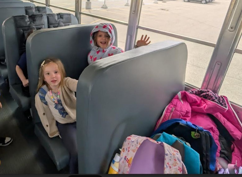 Two girls sitting on the bus together.