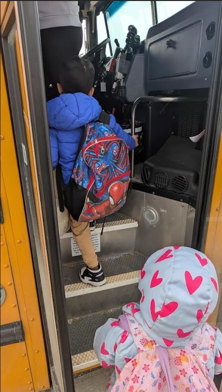 Two students getting on the bus together.