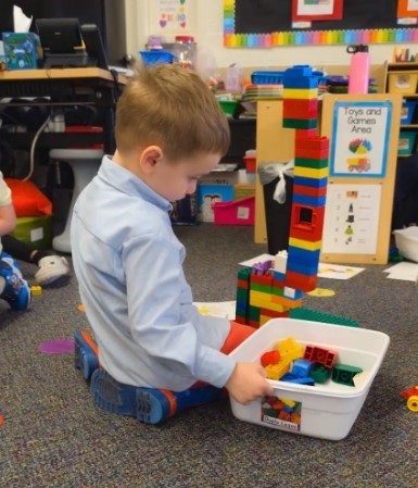 A little boy playing with colorful legos.