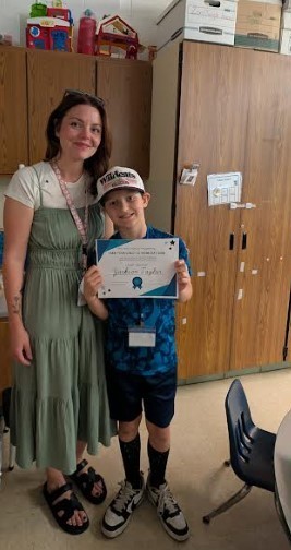 A Mom and her younger son holding a certificate together.