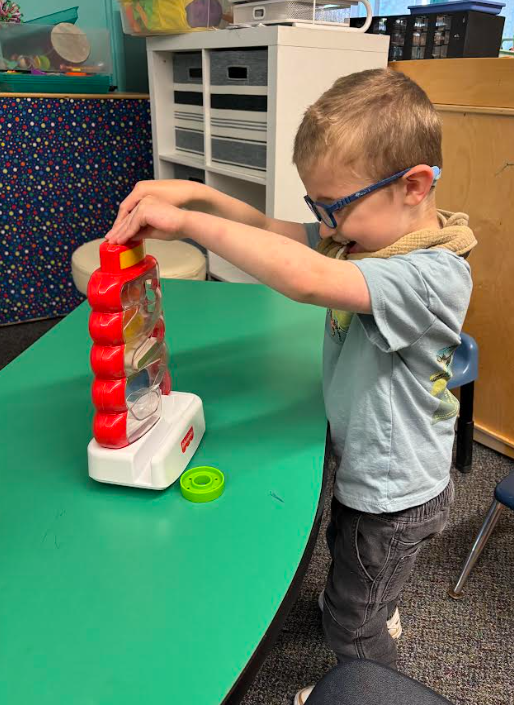 a little boy playing with a ball game.