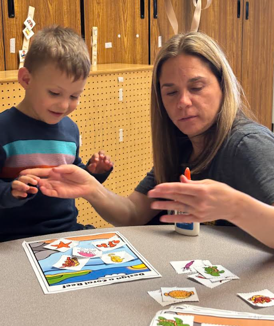 A speech therapist and a little boy matching a puzzle together.