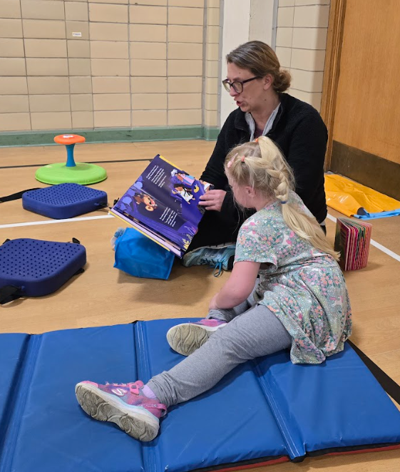 A grandmother and her grandchild reading a book together. 