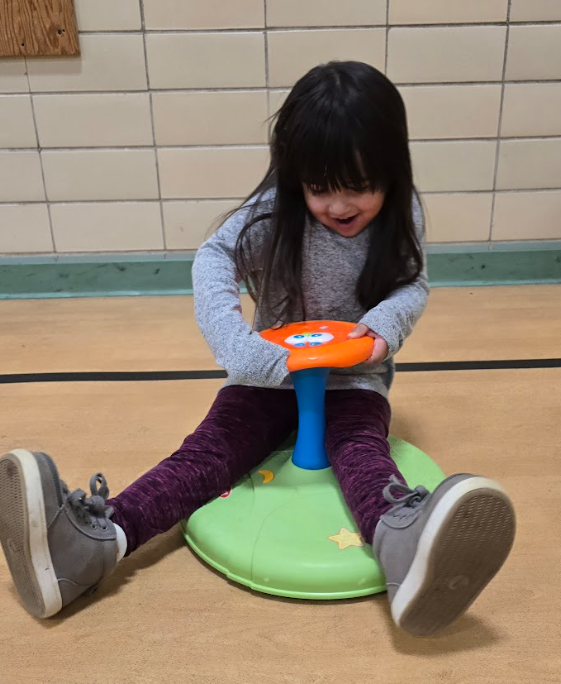A girl sitting on a sit and spin.