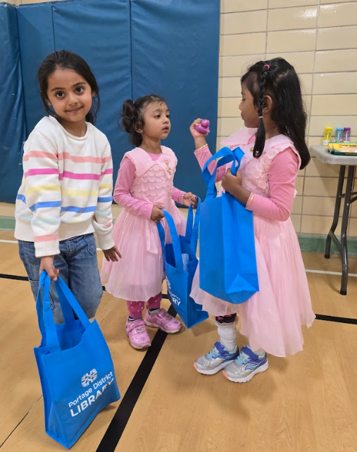 Three preschool students in pink dresses. 