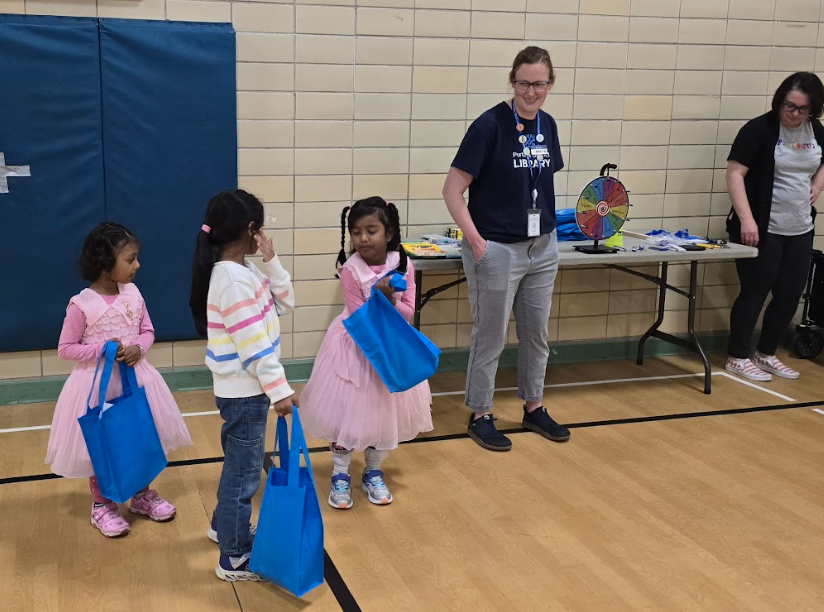 Three girls talking to a librarian . 