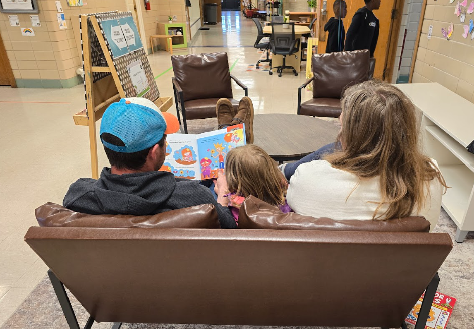 A mom and dad reading a book.
