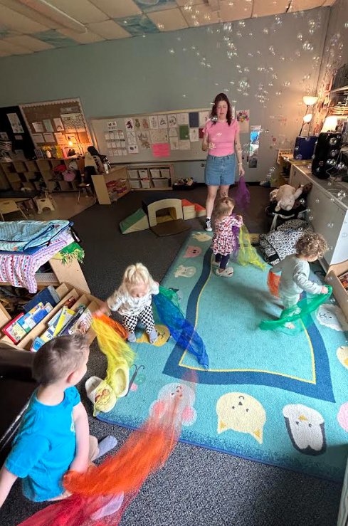 A group of students playing with bubbles in a classroom.