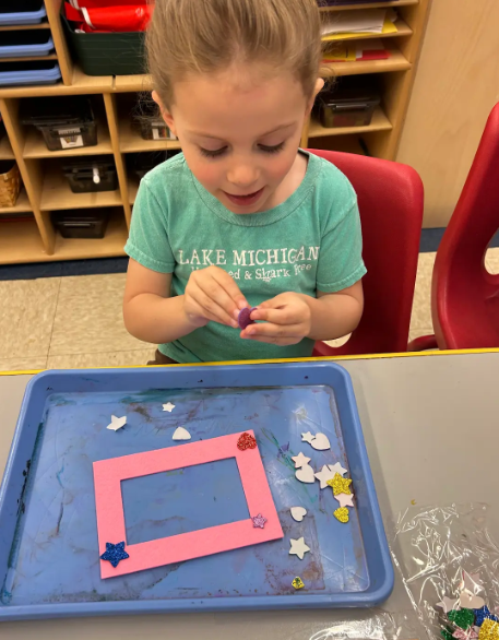 A female student making a homemade picture frame.