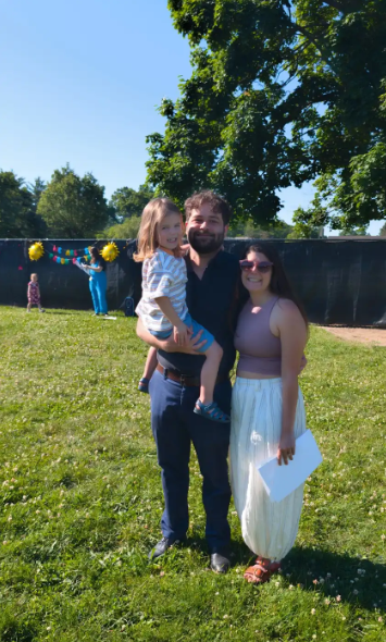 Two parents and a child posing for a picture together. 