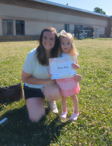 Student and her Mom holding a certificate together. 