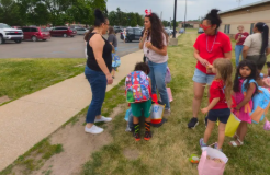 Teacherstanding outside with students to say goodbye.
