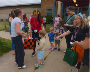 Teachers and parents hugging children.